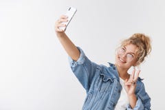 Стильный модный популярный женский белокурый блоггер интернета принимая selfie рекордную руку простирания vlog вверх по верхн-угл стоковое изображение Стильный модный популярный женский белокурый блоггер интернета принимая selfie рекордную руку простирания vlog вверх по верхн-угл стоковое изображение