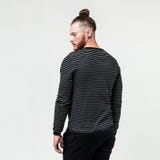 Стильный молодой человек со стилем причесок бороды и плюшки нося темного striped прыгуна и брюк представляет представления в студ стоковые изображения rf Стильный молодой человек со стилем причесок бороды и плюшки нося темного striped прыгуна и брюк представляет представления в студ стоковые изображения rf