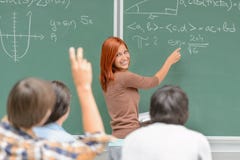 Студент математики пишет на зеленых одноклассниках доски стоковая фотография Студент математики пишет на зеленых одноклассниках доски стоковая фотография