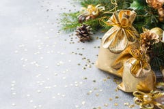 Сумки золота с подарками рождества на предпосылке рождественских елок и предпосылки украшений серой Концепция приветствиям Нового стоковое фото rf Сумки золота с подарками рождества на предпосылке рождественских елок и предпосылки украшений серой Концепция приветствиям Нового стоковое фото rf