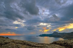 Сценарное небо на заходе солнца над заливом в Sudak, на Чёрном море в Крыме стоковые фотографии rf Сценарное небо на заходе солнца над заливом в Sudak, на Чёрном море в Крыме стоковые фотографии rf