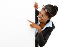 Счастливая Афро-американская женщина указывая на предпосылку белизны знака афиши стоковые фото Счастливая Афро-американская женщина указывая на предпосылку белизны знака афиши стоковые фото