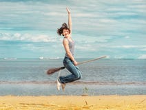 Счастливая женщина при веник скача на пляж стоковые фотографии rf Счастливая женщина при веник скача на пляж стоковые фотографии rf