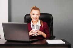 Счастливая коммерсантка с чашкой на офисе стоковые фото Счастливая коммерсантка с чашкой на офисе стоковые фото