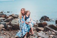 Счастливая мать и дочь обернутые в лоскутном одеяле укрывают тратить время совместно на пляже на летних каникулах Счастливый путе Стоковое Изображение RF Счастливая мать и дочь обернутые в лоскутном одеяле укрывают тратить время совместно на пляже на летних каникулах Счастливый путе Стоковое Изображение RF