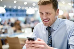 Счастливая молодая исполнительная власть используя умный телефон стоковое изображение Счастливая молодая исполнительная власть используя умный телефон стоковое изображение