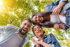 Счастливая молодая семья стоя совместно и усмехаясь на камере в парке стоковое фото rf Счастливая молодая семья стоя совместно и усмехаясь на камере в парке стоковое фото rf