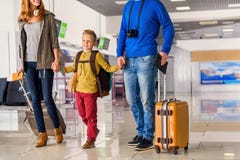Счастливая семья с чемоданами в авиапорте стоковое фото Счастливая семья с чемоданами в авиапорте стоковое фото