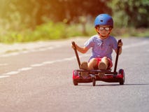 Счастливый мальчик стоя на hoverboard или gyroscooter с доступом kart стоковое фото rf Счастливый мальчик стоя на hoverboard или gyroscooter с доступом kart стоковое фото rf