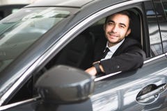 Счастливый усмехаясь водитель в автомобиле, портрет молодого успешного бизнесмена Стоковое Фото Счастливый усмехаясь водитель в автомобиле, портрет молодого успешного бизнесмена Стоковое Фото