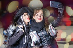 2 счастливых девушки одетых вычурой делают selfie на мобильном телефоне стоковые изображения 2 счастливых девушки одетых вычурой делают selfie на мобильном телефоне стоковые изображения