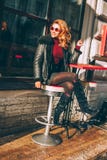 Счастливая женщина Redhead смеясь над в кафе улицы Стоковое Изображение Счастливая женщина Redhead смеясь над в кафе улицы Стоковое Изображение