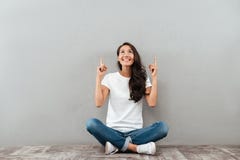 Счастливая жизнерадостная азиатская женщина сидя на поле стоковые фото Счастливая жизнерадостная азиатская женщина сидя на поле стоковые фото