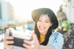 Счастливая китайская женщина influencer делая фото на каникулах - молодую ультрамодную азиатскую девушку принимая selfie на откры стоковое фото rf Счастливая китайская женщина influencer делая фото на каникулах - молодую ультрамодную азиатскую девушку принимая selfie на откры стоковое фото rf