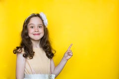 Счастливая маленькая девочка на желтых пунктах предпосылки ее палец на космосе для помечать буквами r стоковые фото Счастливая маленькая девочка на желтых пунктах предпосылки ее палец на космосе для помечать буквами r стоковые фото