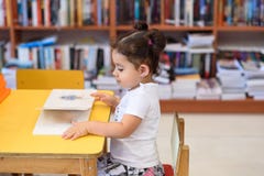 Счастливая маленькая девочка ребенка читая книгу стоковые изображения Счастливая маленькая девочка ребенка читая книгу стоковые изображения