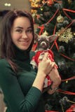Счастливая маленькая девочка с собакой одетой в одеждах Санта Клауса на предпосылке рождественской елки стоковое фото rf Счастливая маленькая девочка с собакой одетой в одеждах Санта Клауса на предпосылке рождественской елки стоковое фото rf