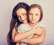 Счастливая мать и возбужденная joying девушка ребенк обнимая с эмоциональными усмехаясь сторонами на пурпурной предпосылке с пуст стоковые изображения Счастливая мать и возбужденная joying девушка ребенк обнимая с эмоциональными усмехаясь сторонами на пурпурной предпосылке с пуст стоковые изображения