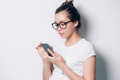 Счастливая молодая женщина брюнета усмехаясь и используя смартфон на белой предпосылке Современная технология, интернет, сообщени стоковая фотография Счастливая молодая женщина брюнета усмехаясь и используя смартфон на белой предпосылке Современная технология, интернет, сообщени стоковая фотография