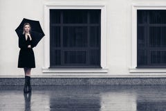 Счастливая молодая женщина моды с зонтиком идя в улицу города стоковые фотографии rf Счастливая молодая женщина моды с зонтиком идя в улицу города стоковые фотографии rf