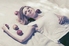 Счастливая молодая женщина при яблоки лежа на шотландке внешней Стоковые Изображения Счастливая молодая женщина при яблоки лежа на шотландке внешней Стоковые Изображения