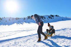 Счастливая молодая семья играя в свежем снеге на красивом солнечном зимнем дне внешнем в природе стоковые изображения rf Счастливая молодая семья играя в свежем снеге на красивом солнечном зимнем дне внешнем в природе стоковые изображения rf