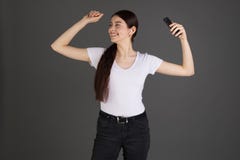 Счастливая положительная женщина брюнета в белой футболке и темных джинсах стоковая фотография Счастливая положительная женщина брюнета в белой футболке и темных джинсах стоковая фотография
