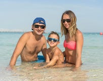 Счастливая семья имея потеху на тропическом белом пляже Мать, отец, стоковое изображение rf Счастливая семья имея потеху на тропическом белом пляже Мать, отец, стоковое изображение rf