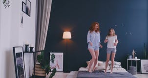 Счастливая семья милой дочери и молодая мать скача и танцуя на промежутке времени кровати имеют потеху во время утра на праздника сток-видео Счастливая семья милой дочери и молодая мать скача и танцуя на промежутке времени кровати имеют потеху во время утра на праздника сток-видео