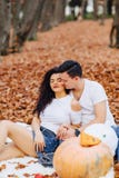 Счастливая семья с меньшим милым ребенком в парке на желтых лист с стоковые изображения Счастливая семья с меньшим милым ребенком в парке на желтых лист с стоковые изображения