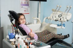 Счастливая терпеливая девушка показывая большие пальцы руки вверх на зубоврачебном офисе клиники Концепция медицины, стоматологии стоковая фотография rf Счастливая терпеливая девушка показывая большие пальцы руки вверх на зубоврачебном офисе клиники Концепция медицины, стоматологии стоковая фотография rf