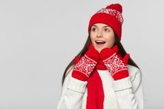 Счастливая удивленная женщина смотря косой в ободрении Excited девушка рождества нося связанную теплые шляпу и шарф, изолированны Стоковое Изображение RF Счастливая удивленная женщина смотря косой в ободрении Excited девушка рождества нося связанную теплые шляпу и шарф, изолированны Стоковое Изображение RF