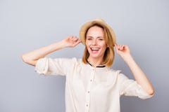 Счастливая усмехаясь женщина в соломенной шляпе имея потеху и положение против стоковое изображение rf Счастливая усмехаясь женщина в соломенной шляпе имея потеху и положение против стоковое изображение rf