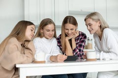 Счастливая усмехаясь лесбосская семья в случайных одеждах, 2 дочерях и усаживании их мамы совместно на таблице в стоковое фото rf Счастливая усмехаясь лесбосская семья в случайных одеждах, 2 дочерях и усаживании их мамы совместно на таблице в стоковое фото rf