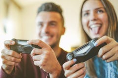 Счастливые друзья играя видеоигры в их квартире - веселые молодые пары имея потеху с технологией консоли нового веяния стоковые изображения rf Счастливые друзья играя видеоигры в их квартире - веселые молодые пары имея потеху с технологией консоли нового веяния стоковые изображения rf