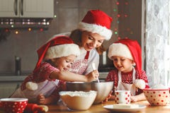 Счастливые мать и дети семьи пекут печенья для рождества стоковые фотографии rf Счастливые мать и дети семьи пекут печенья для рождества стоковые фотографии rf
