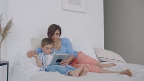 Счастливые мать семьи и сын ребенка с планшетом в вечере Счастливые мать семьи и сын ребенка с планшетом в вечере акции видеоматериалы Счастливые мать семьи и сын ребенка с планшетом в вечере Счастливые мать семьи и сын ребенка с планшетом в вечере акции видеоматериалы