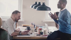 Счастливые многонациональные бизнесмены сотрудничают в просторной квартире coworking Друзья наслаждаются работать совместно в све акции видеоматериалы Счастливые многонациональные бизнесмены сотрудничают в просторной квартире coworking Друзья наслаждаются работать совместно в све акции видеоматериалы