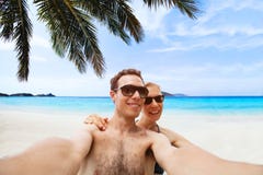 Счастливые молодые пары принимая фото selfie на пляже стоковое фото rf Счастливые молодые пары принимая фото selfie на пляже стоковое фото rf