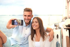 Счастливые пары в влюбленности принимая selfie на паруснике, ослабляя на яхте на море стоковая фотография Счастливые пары в влюбленности принимая selfie на паруснике, ослабляя на яхте на море стоковая фотография