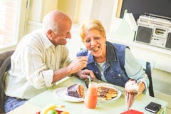 Счастливые пары старшиев есть блинчики в бар-ресторане - выбытые людей имея потеху наслаждаясь обедом совместно стоковая фотография Счастливые пары старшиев есть блинчики в бар-ресторане - выбытые людей имея потеху наслаждаясь обедом совместно стоковая фотография