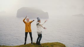 Счастливые танцы женщины 2 на береге моря в Исландии Жизнерадостные ту видеоматериал Счастливые танцы женщины 2 на береге моря в Исландии Жизнерадостные ту видеоматериал