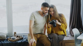Счастливые усмехаясь фото пар наблюдая от перемещения на цифровой фотокамера дома после каникул стоковая фотография rf Счастливые усмехаясь фото пар наблюдая от перемещения на цифровой фотокамера дома после каникул стоковая фотография rf