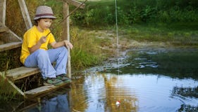 Счастливый мальчик идет удить на реке, одном рыболове детей с a стоковая фотография rf Счастливый мальчик идет удить на реке, одном рыболове детей с a стоковая фотография rf