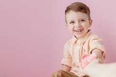 Счастливый мальчик с подарком Фото изолированное на розовой предпосылке Усмехаясь мальчик держит присутствующую коробку Концепция стоковые фотографии rf Счастливый мальчик с подарком Фото изолированное на розовой предпосылке Усмехаясь мальчик держит присутствующую коробку Концепция стоковые фотографии rf