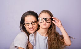 Счастливый молодой случайный ребенк матери и усмехаться в стеклах моды обнимая на пурпурной предпосылке с пустым космосом экземпл стоковое фото rf Счастливый молодой случайный ребенк матери и усмехаться в стеклах моды обнимая на пурпурной предпосылке с пустым космосом экземпл стоковое фото rf