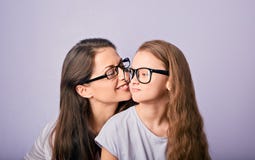 Счастливый молодой случайный ребенк матери и усмехаться в стеклах моды обнимая и смотря один другого на пурпурной предпосылке с п стоковые изображения rf Счастливый молодой случайный ребенк матери и усмехаться в стеклах моды обнимая и смотря один другого на пурпурной предпосылке с п стоковые изображения rf