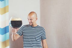 Счастливый, молодой человек с очень большой кружкой пива Он смеется над и радоваться, и после этого пить стоковое изображение Счастливый, молодой человек с очень большой кружкой пива Он смеется над и радоваться, и после этого пить стоковое изображение