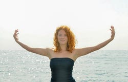 Счастливый счастливый портрет молодой элегантной рыжеволосой курчавой женщины с протягиванными оружиями морем на пляже в Италии с стоковое фото Счастливый счастливый портрет молодой элегантной рыжеволосой курчавой женщины с протягиванными оружиями морем на пляже в Италии с стоковое фото