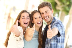 3 счастливых друз усмехаясь с большими пальцами руки вверх в улице стоковые изображения 3 счастливых друз усмехаясь с большими пальцами руки вверх в улице стоковые изображения